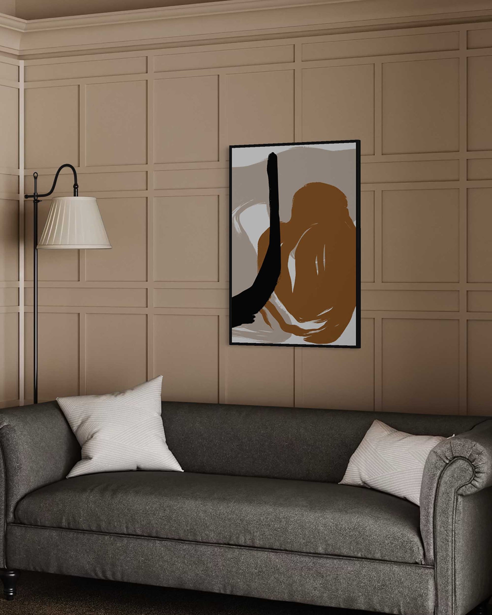 Abstract art piece on a wall above a gray sofa with a lamp and decorative pillows.