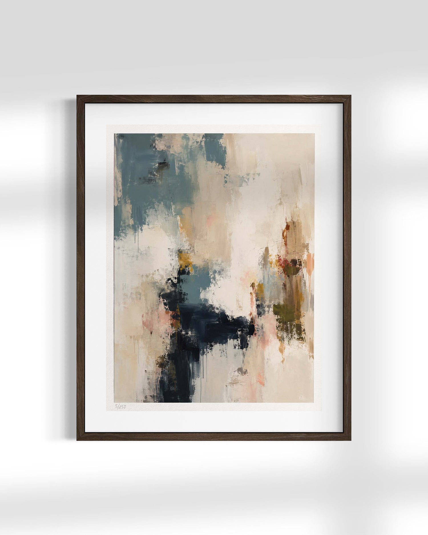 A framed abstract art print featuring textured brushstrokes in beige, slate blue, charcoal, and soft orange, presented in a dark brown frame with a white mat against a light gray wall.
