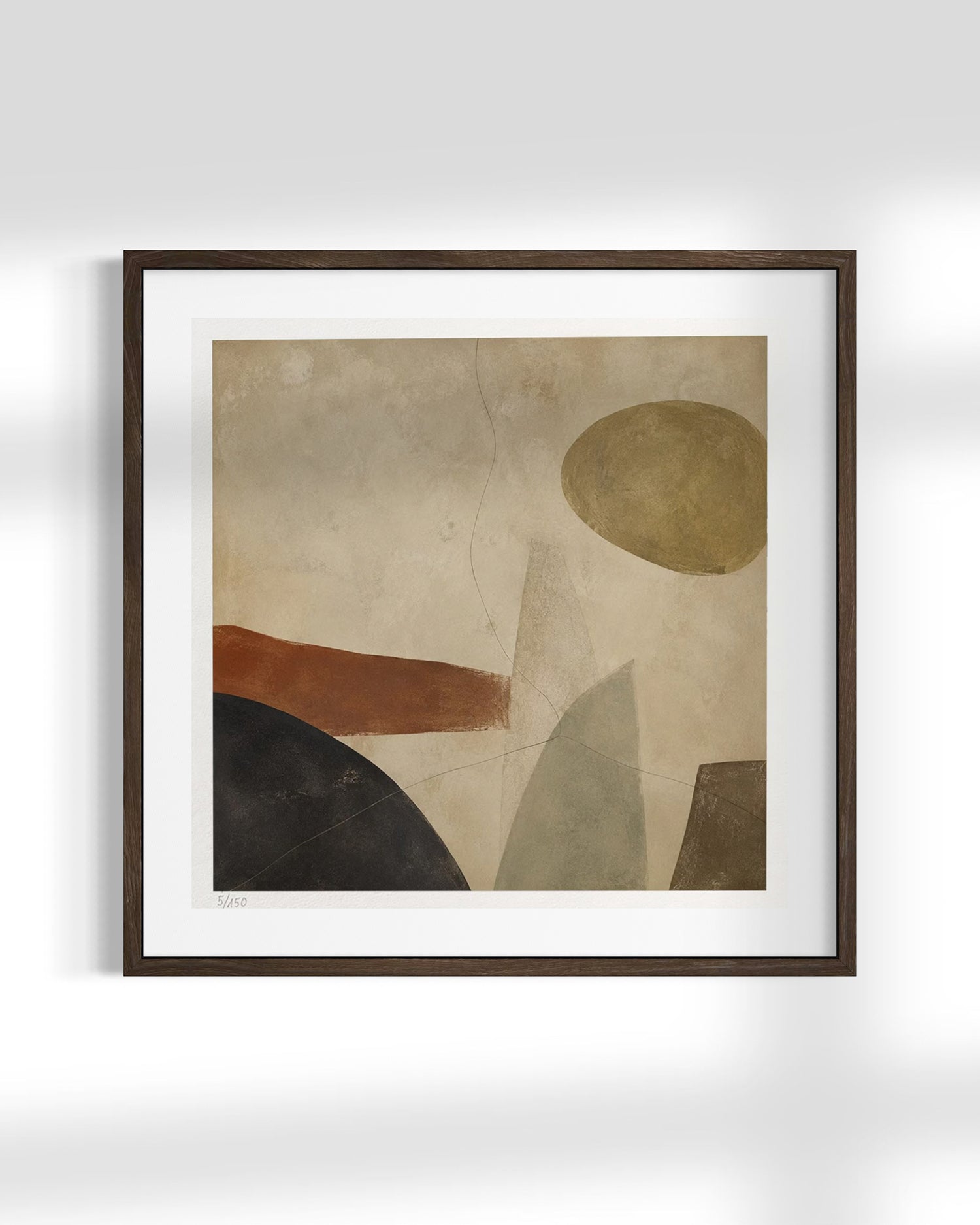Framed abstract wall art featuring geometric shapes in beige, brown, black, and muted green tones, displayed against a light gray wall.