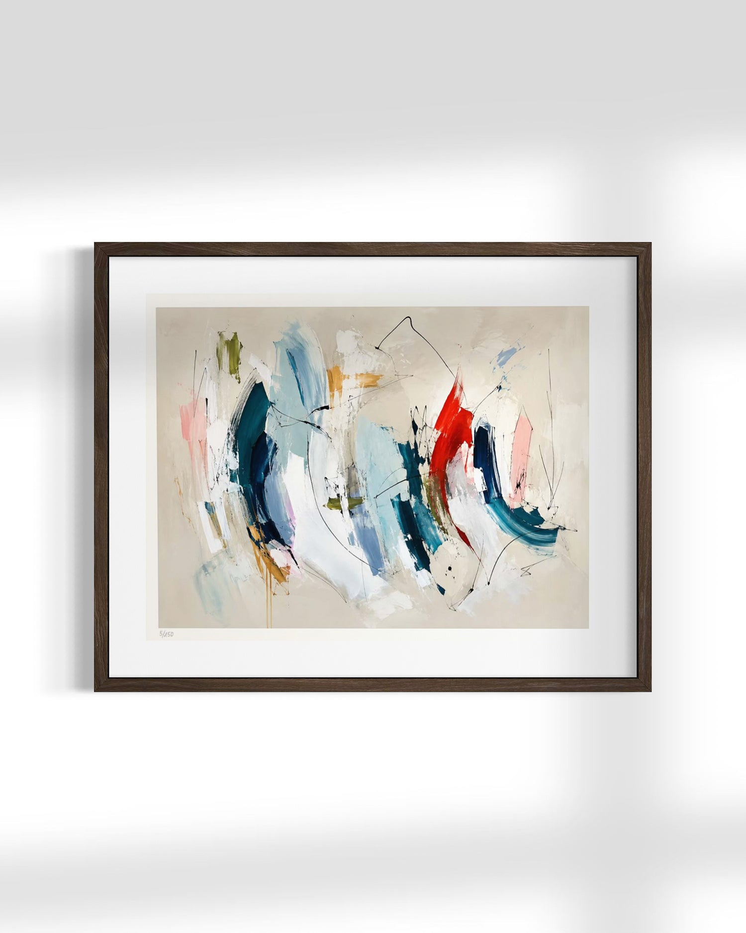 Framed abstract wall art hanging on a white wall, featuring expressive brushstrokes in blue, white, red, pink, and beige tones within a dark wood frame and white mat.