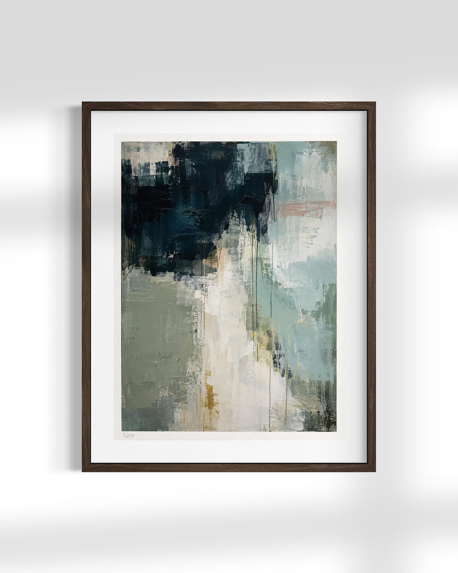 Framed abstract wall art print with a dark brown frame and white mat, featuring an abstract painting with navy, sage green, cream, and soft gray brushstrokes, displayed on a light gray wall.