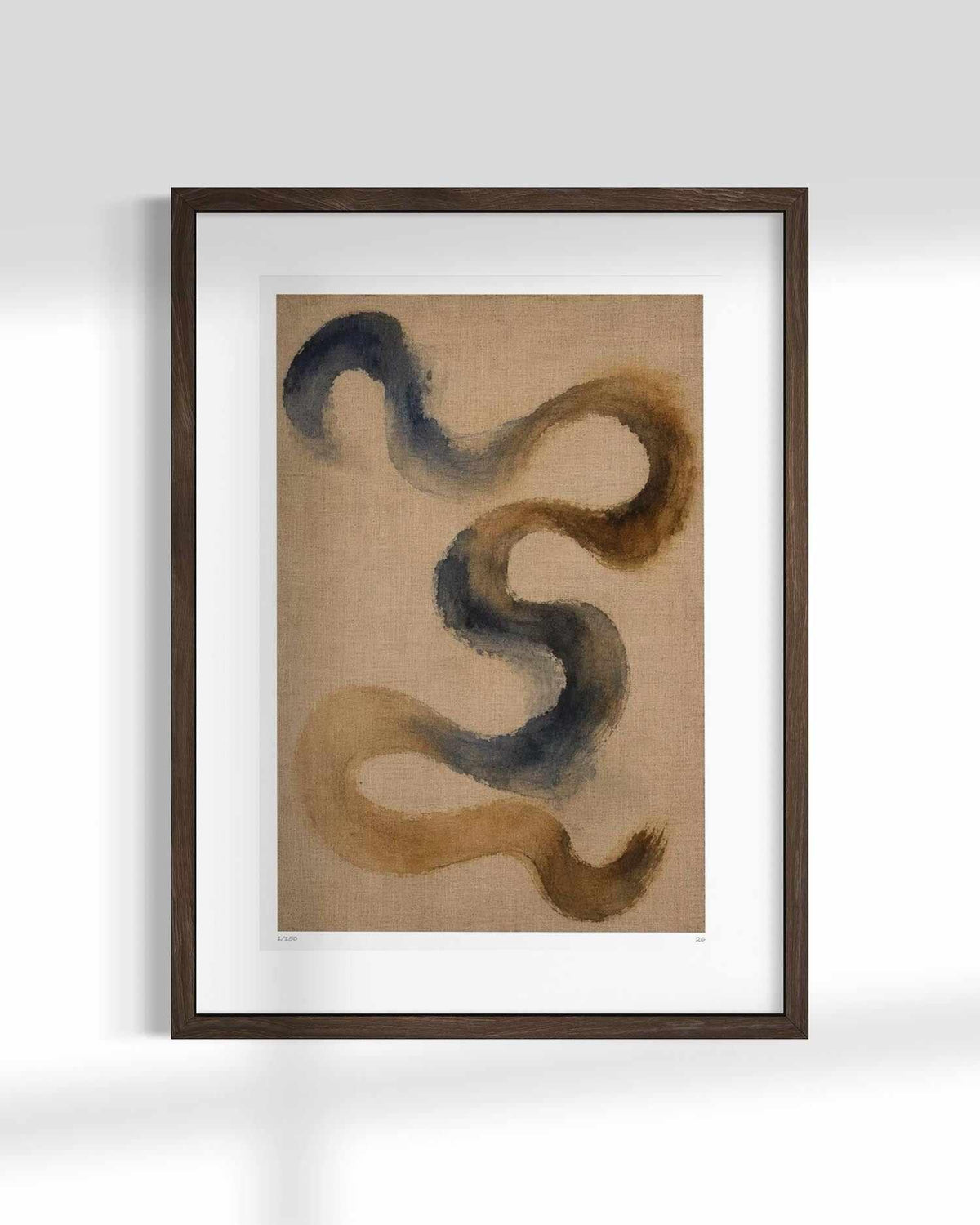Framed abstract wall art featuring flowing, snake-like brushstrokes in dark blue-gray and warm brown on a tan textured background, shown in a dark wood frame with a white mat against a light gray wall.