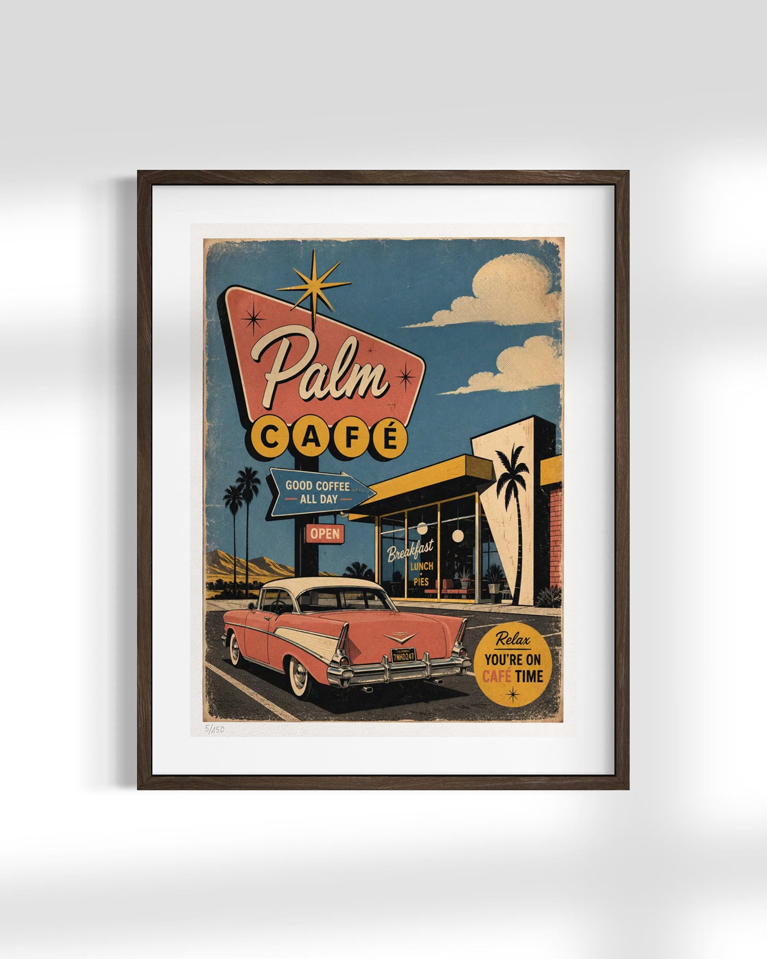 A framed retro-style art print of a vintage 'Palm Cafe' poster, featuring a pink classic car, a retro sign, and a blue sky, displayed on a clean white wall.