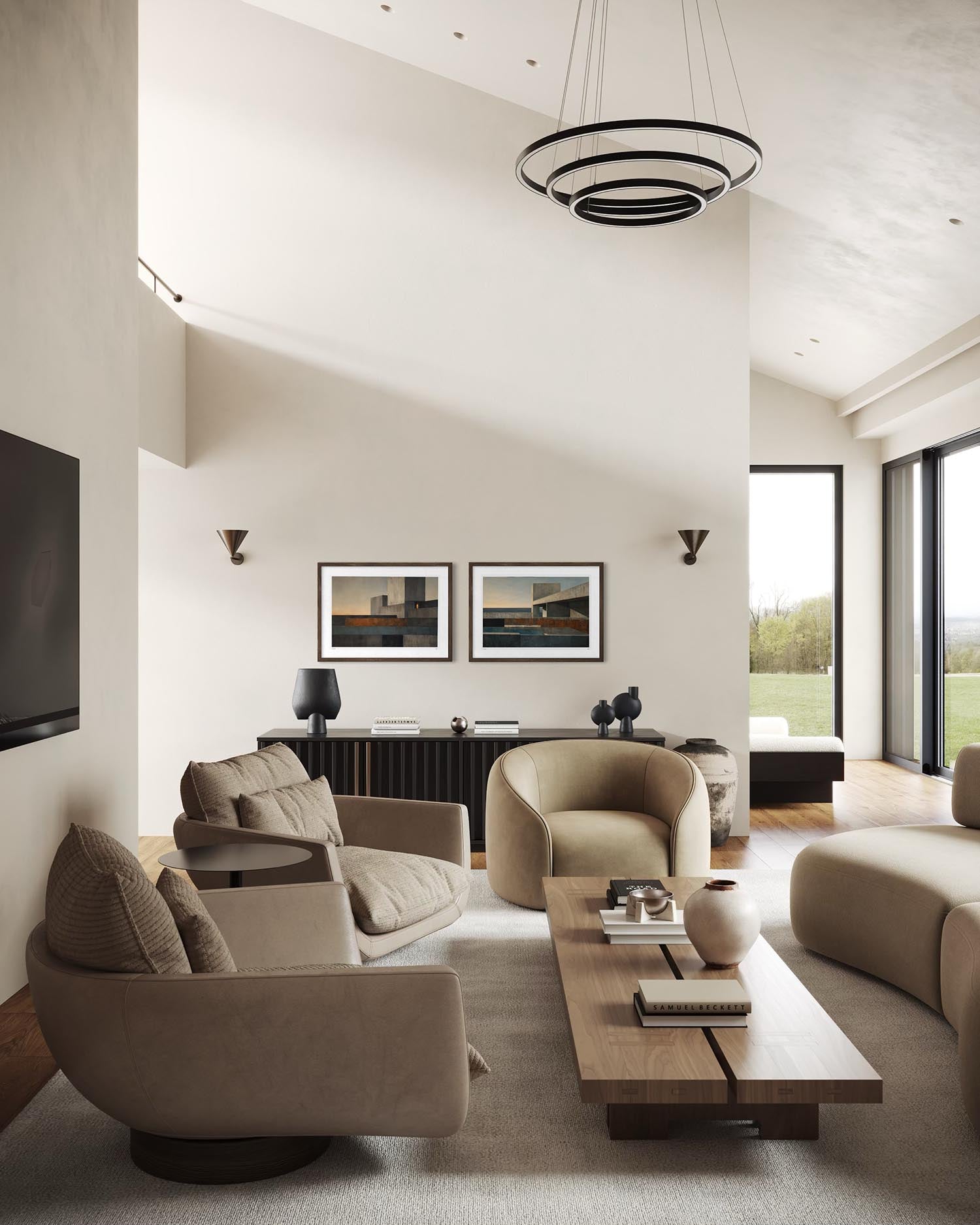 A modern, high-ceilinged living room with beige upholstered armchairs, a matching sofa, a wooden coffee table, and a black circular chandelier. Two framed landscape prints hang on the wall above a dark console table.