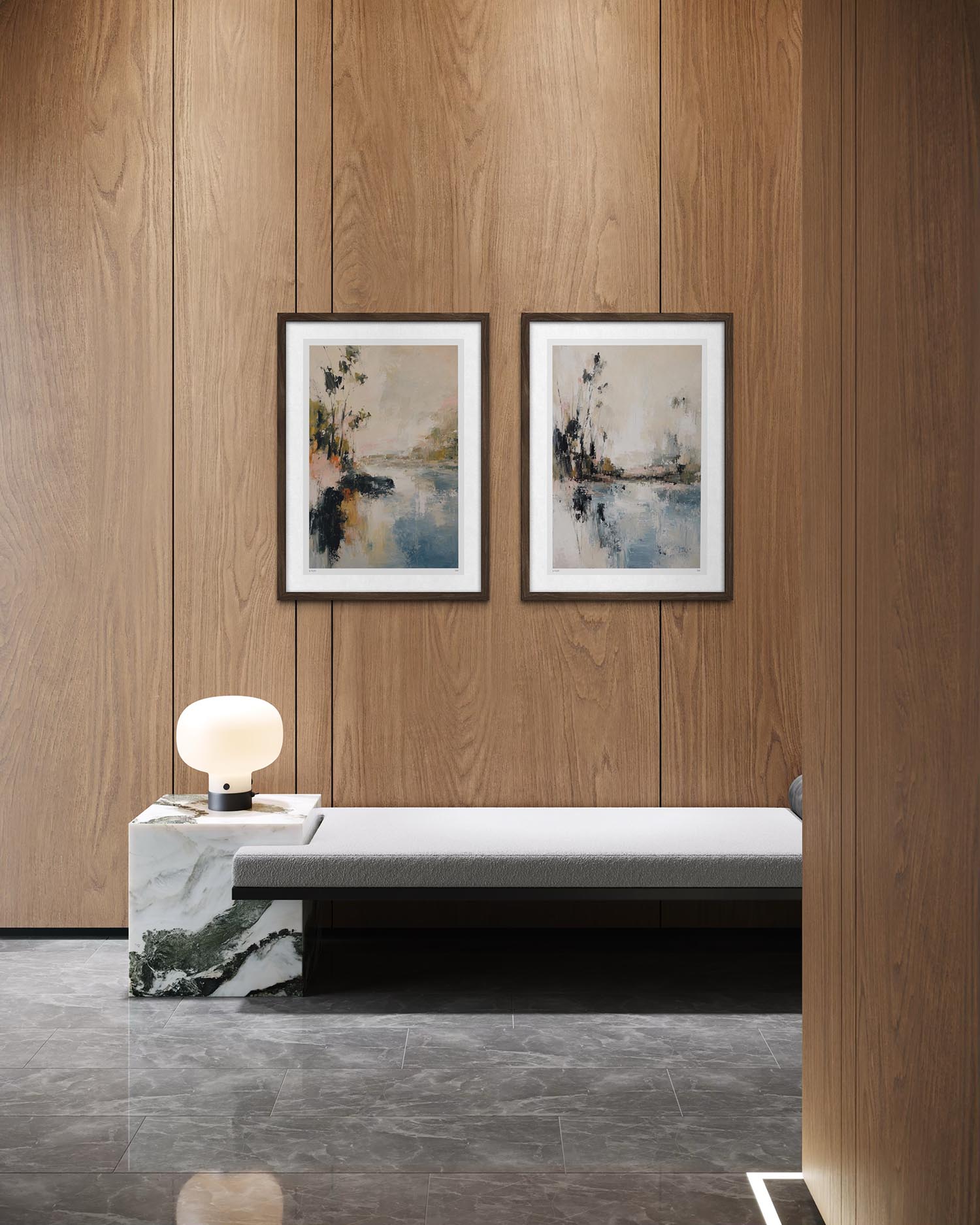 A modern interior scene with two framed abstract landscape paintings hanging on a wood-paneled wall above a low bench and marble side table with a glowing lamp.
