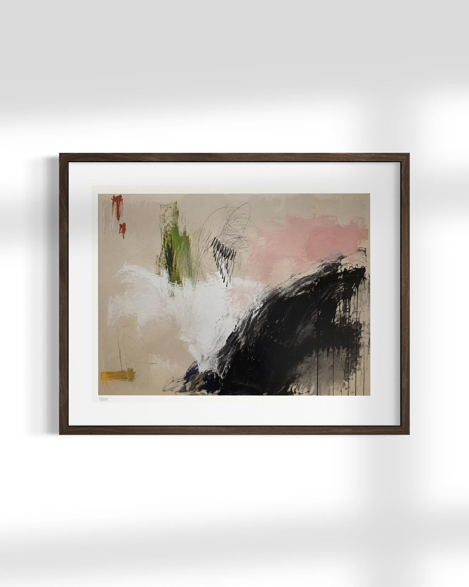 Framed abstract wall art hanging on a light gray wall, featuring a dark brown wood frame, white mat, and an abstract painting with beige, pink, black, green, and white brushstrokes.