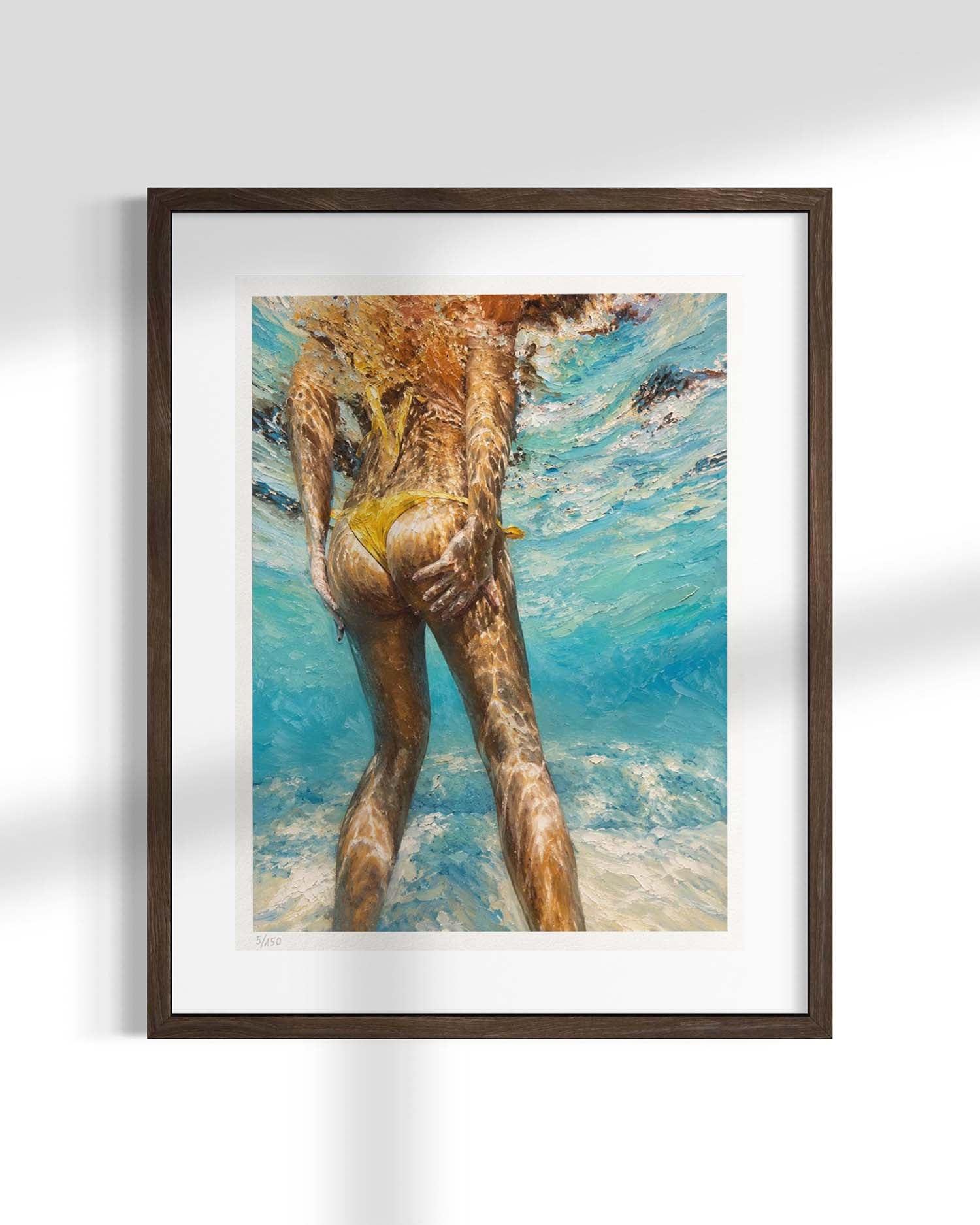 A framed art print featuring an underwater photograph of a person from behind in turquoise water, set in a dark brown frame with a white mat, displayed on a light gray wall.