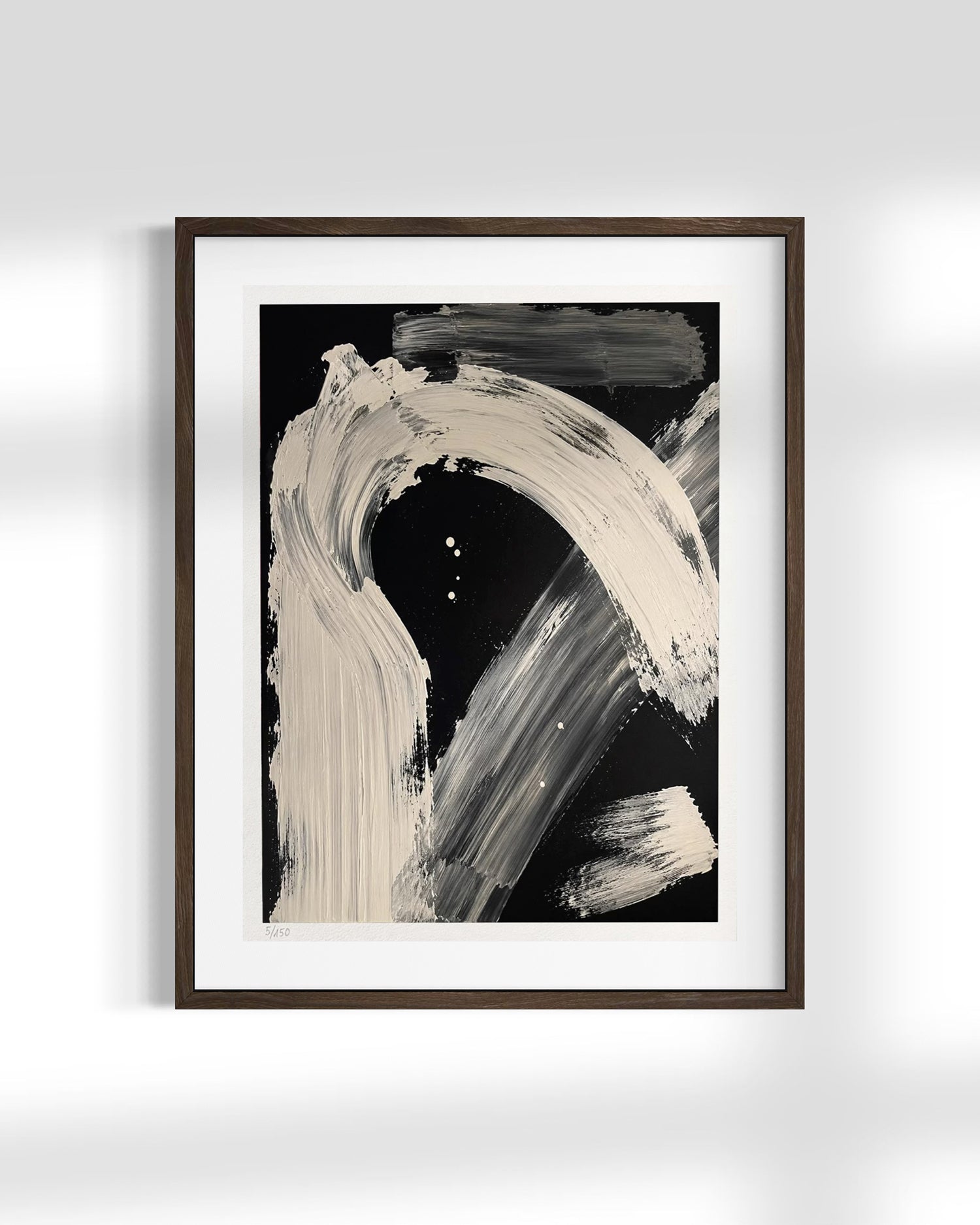 Framed abstract wall art featuring bold off-white and gray brushstrokes on a black background, presented in a dark wood frame with a white mat against a light gray wall.