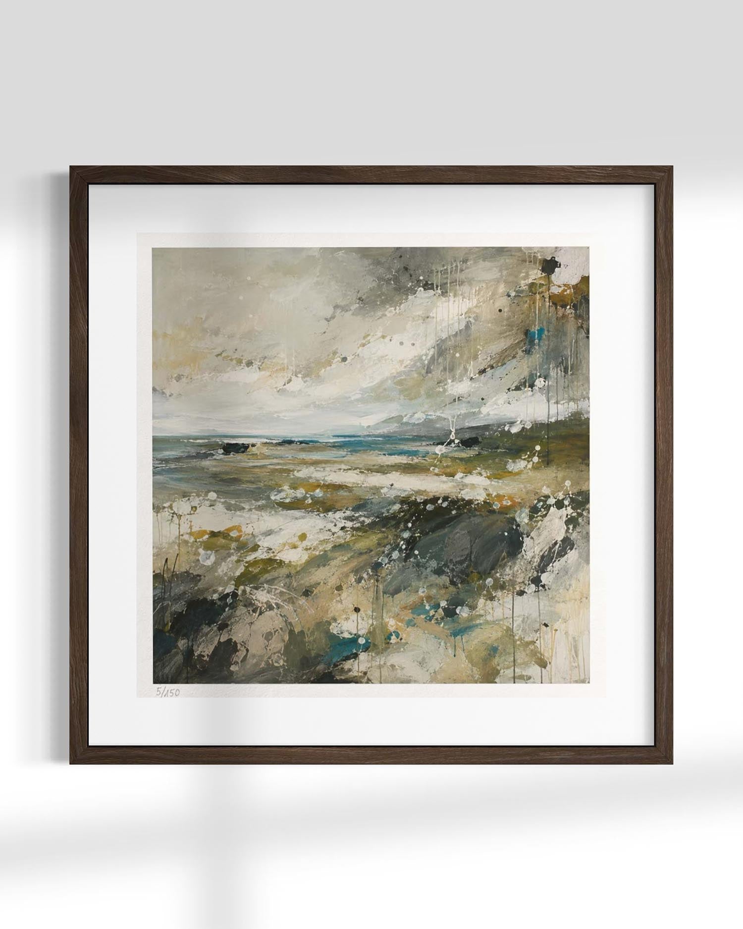 Framed abstract landscape painting with a dark brown wood frame and white mat, featuring earthy tones of beige, gray, green, and blue on a light gray wall background.
