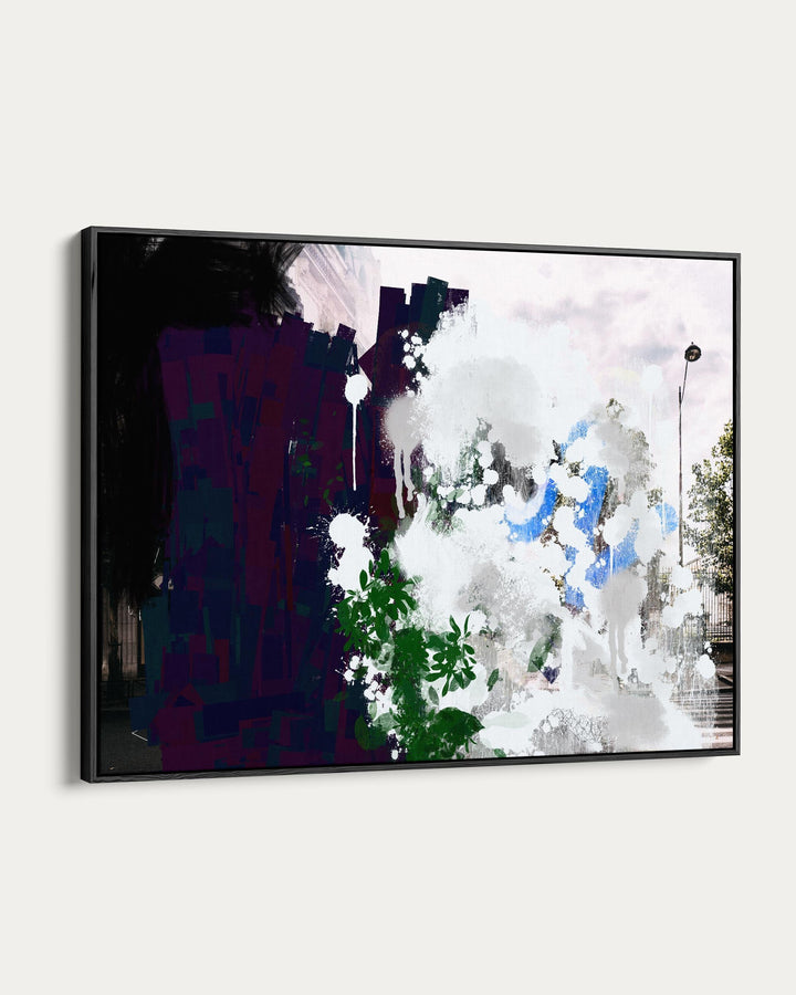 Framed abstract artwork with splashes of color on a white wall