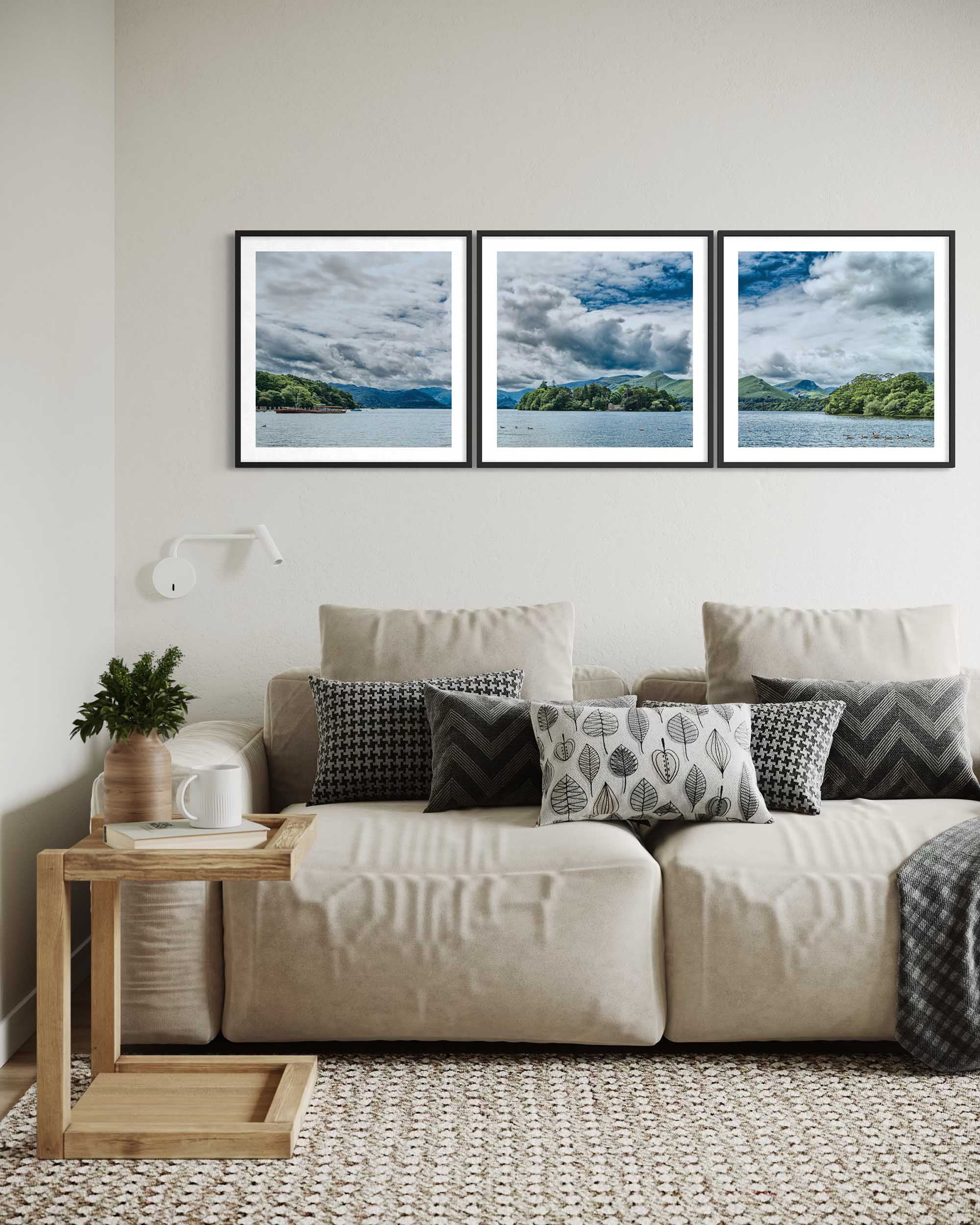 Living room with a beige sofa, wooden side table, and three framed landscape pictures on the wall.