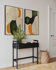 Two abstract art pieces on a wall above a black console table with decorative items.