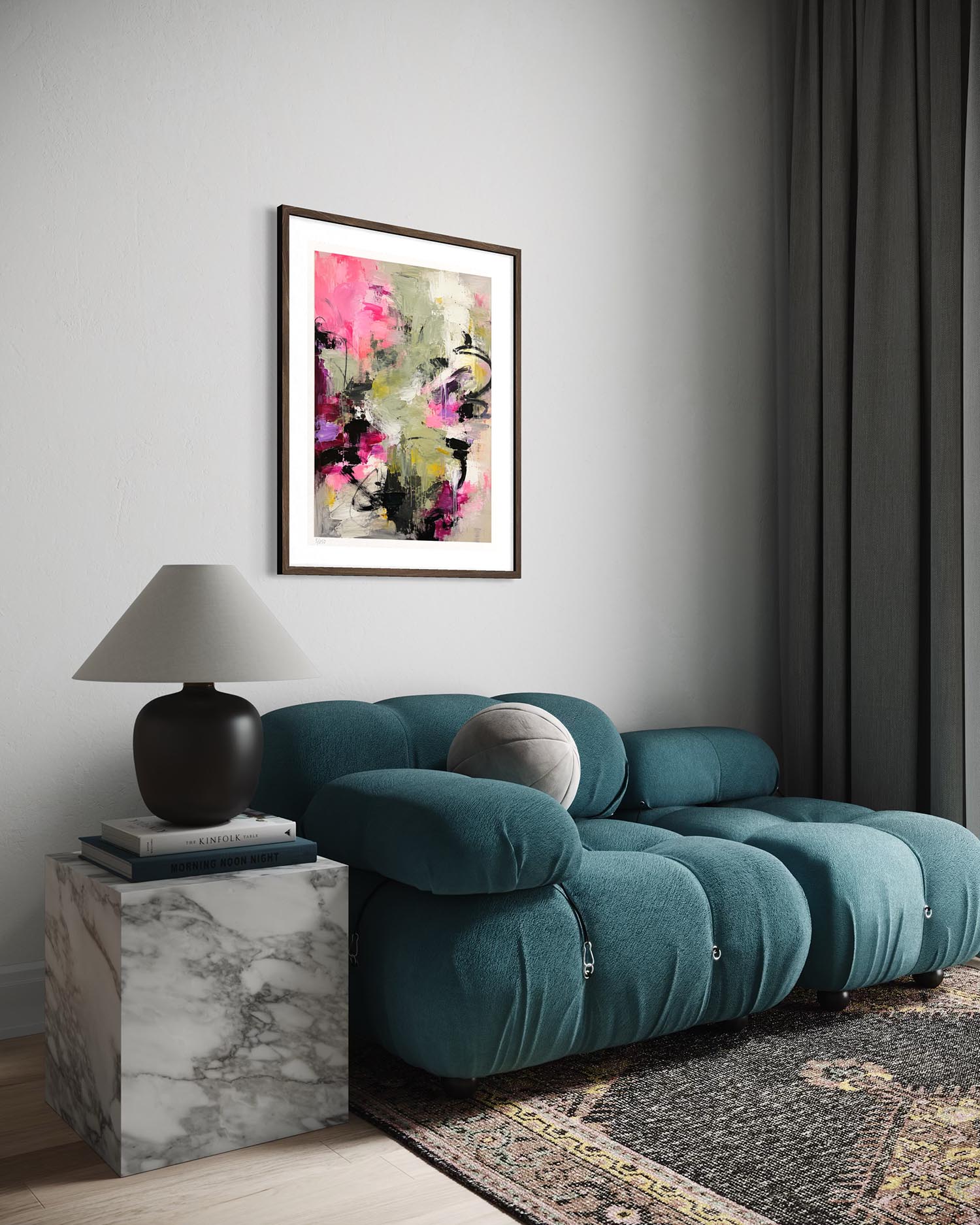 A framed abstract art print featuring vibrant pink, magenta, and black brushstrokes on a light background, styled in a modern living room above a teal tufted sofa.