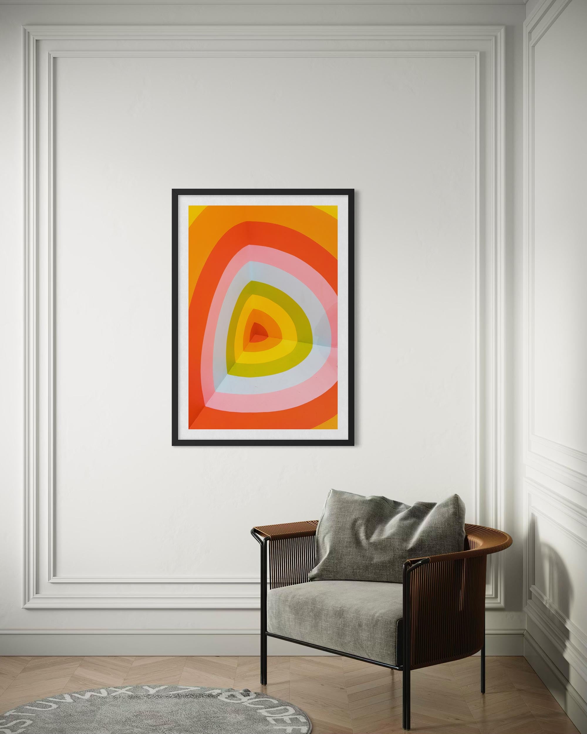 Colorful abstract art piece on a wall above a chair with a gray cushion.