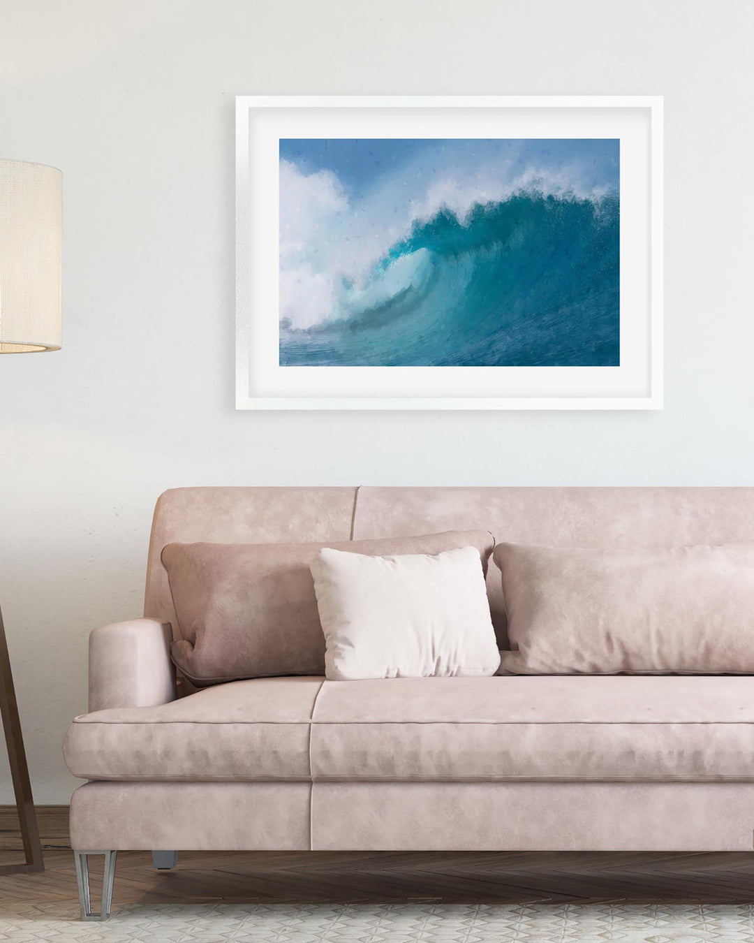 Framed photograph of a blue wave above a beige sofa with a lamp on the left.