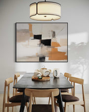 Dining room with a black table and wooden chairs, abstract art on the wall, and a chandelier.