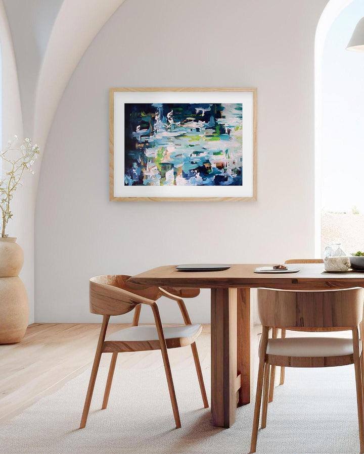 Dining room with wooden table and chairs, abstract painting on the wall, and a vase with plants.