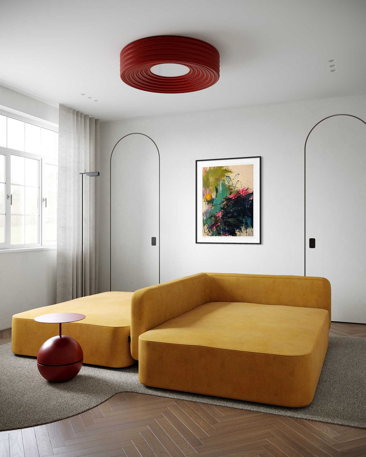 A modern living room featuring a mustard yellow velvet modular sofa and matching ottoman, a red ribbed ceiling light, and a framed abstract painting on a white wall.