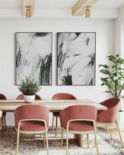 Dining room with abstract art on the wall, pink chairs, and a wooden table.