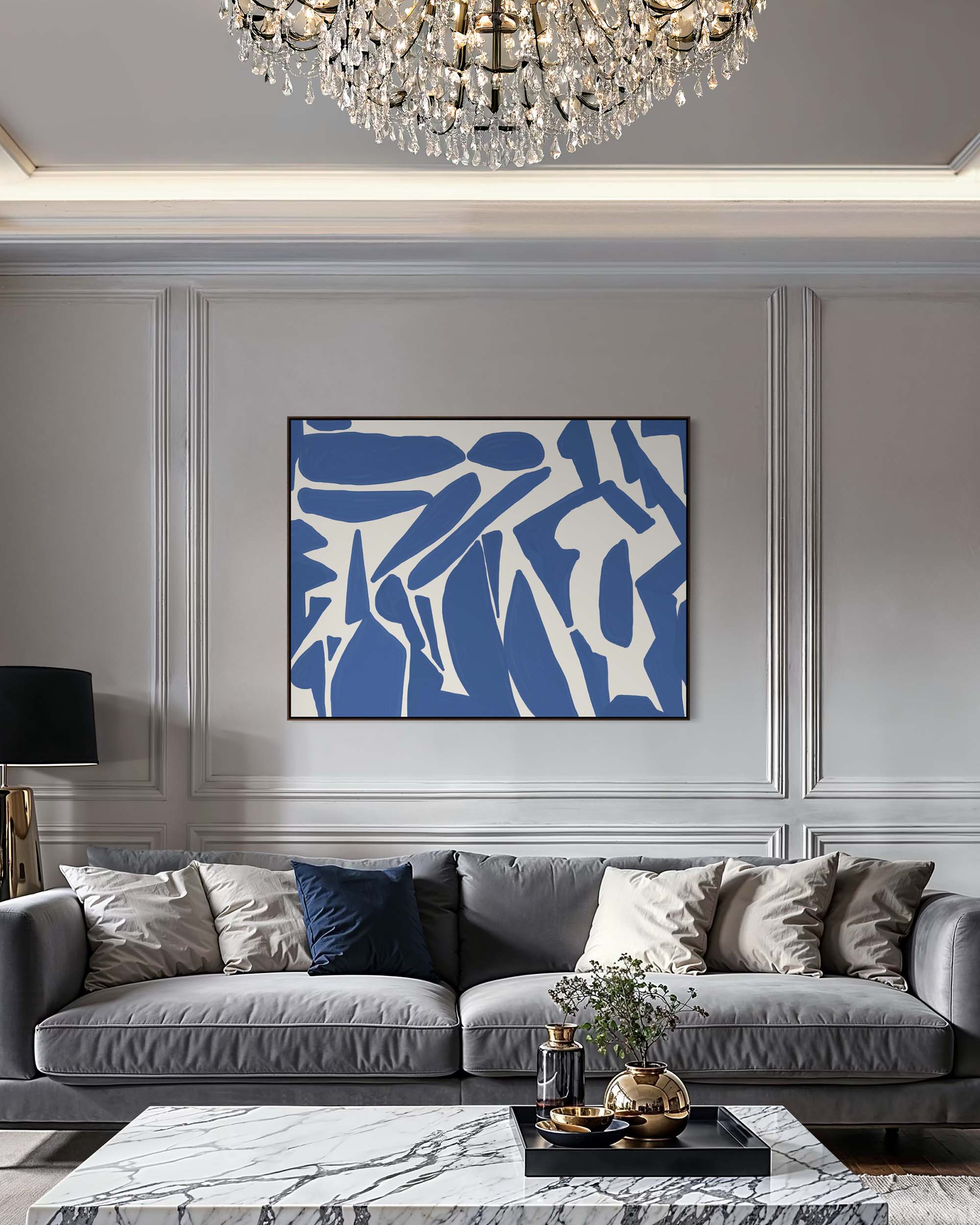 Modern living room with gray sofa, abstract blue and white painting, and chandelier.