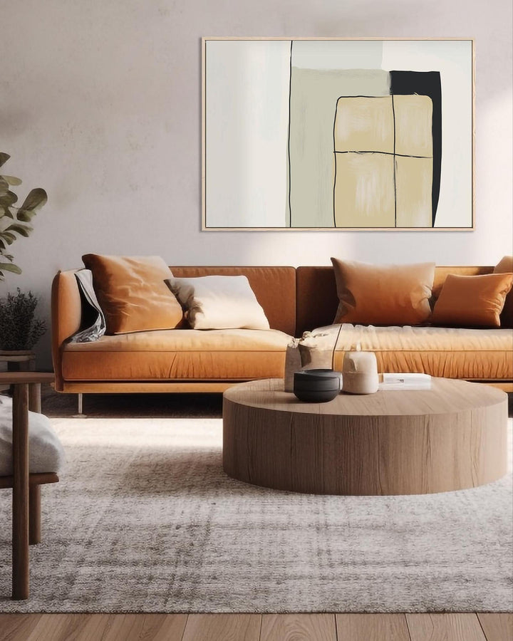 Modern living room with brown sofa, round coffee table, and abstract art on the wall.