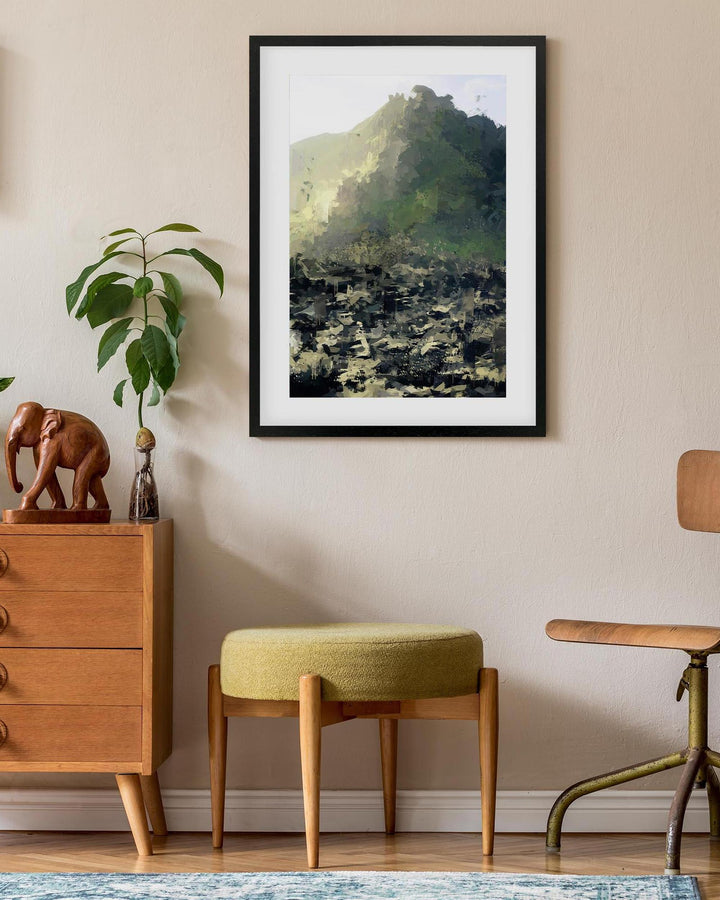 Framed landscape print on a wall above a wooden dresser with decorative items.