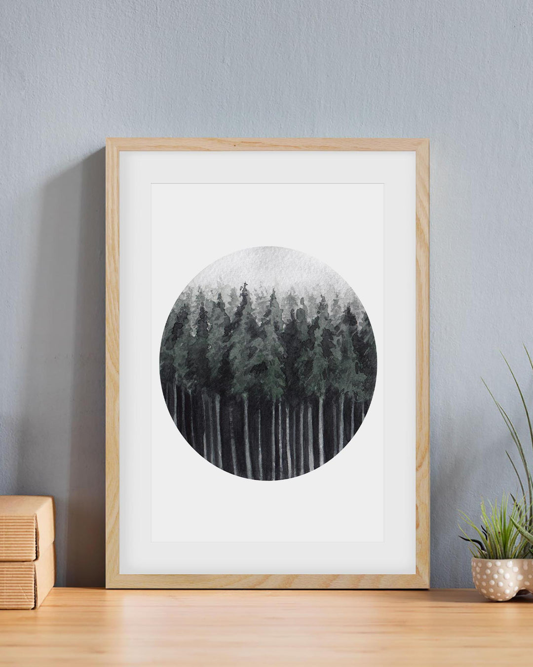 Framed artwork of a forest scene on a wall