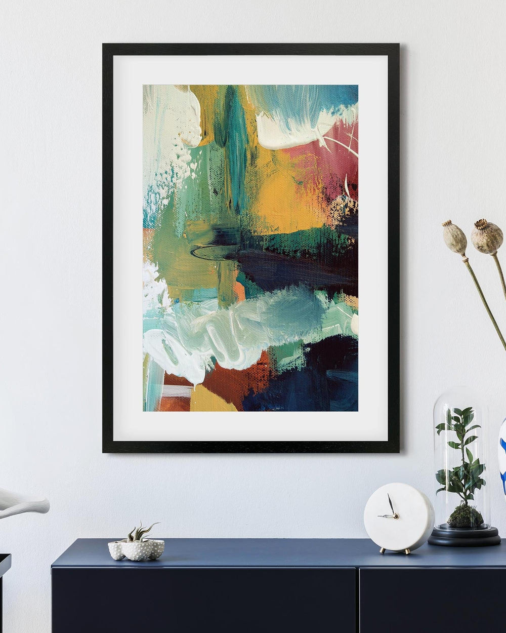 Framed abstract art piece on a wall above a console table with decorative items.