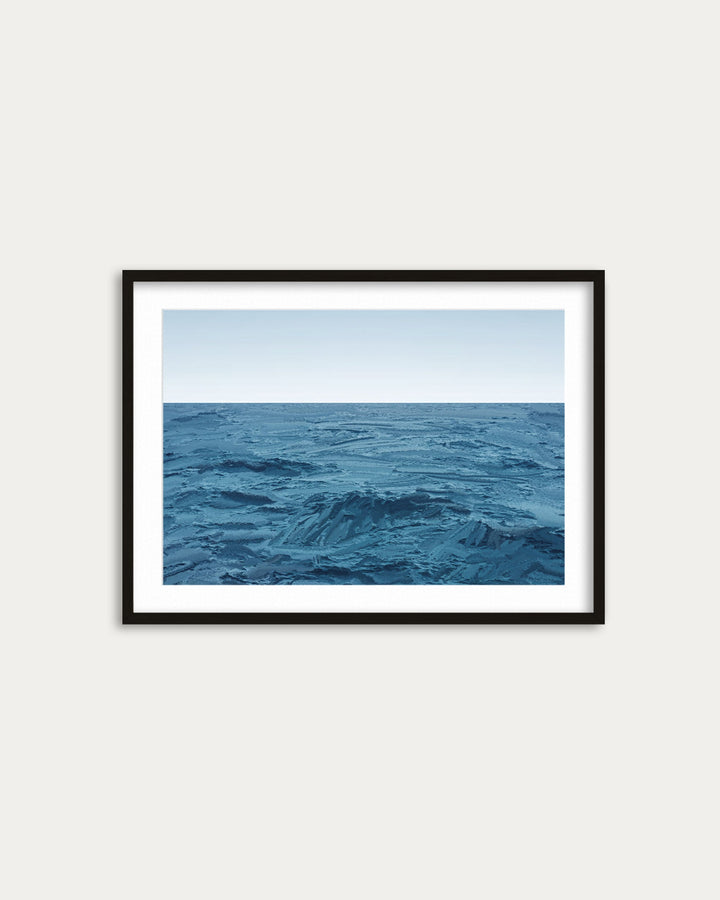 Framed artwork of a blue ocean scene on a white wall