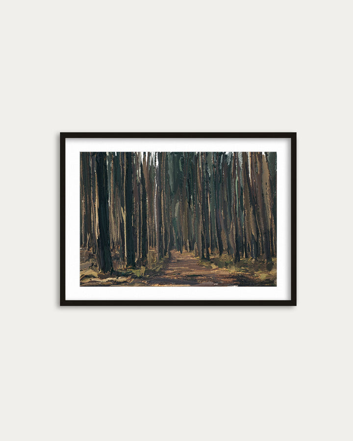 Framed painting of a forest path on a white wall