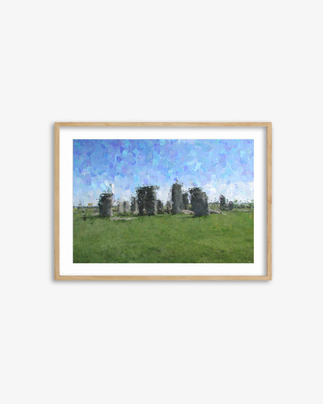 Framed artwork of Stonehenge with a blue sky and green grass.