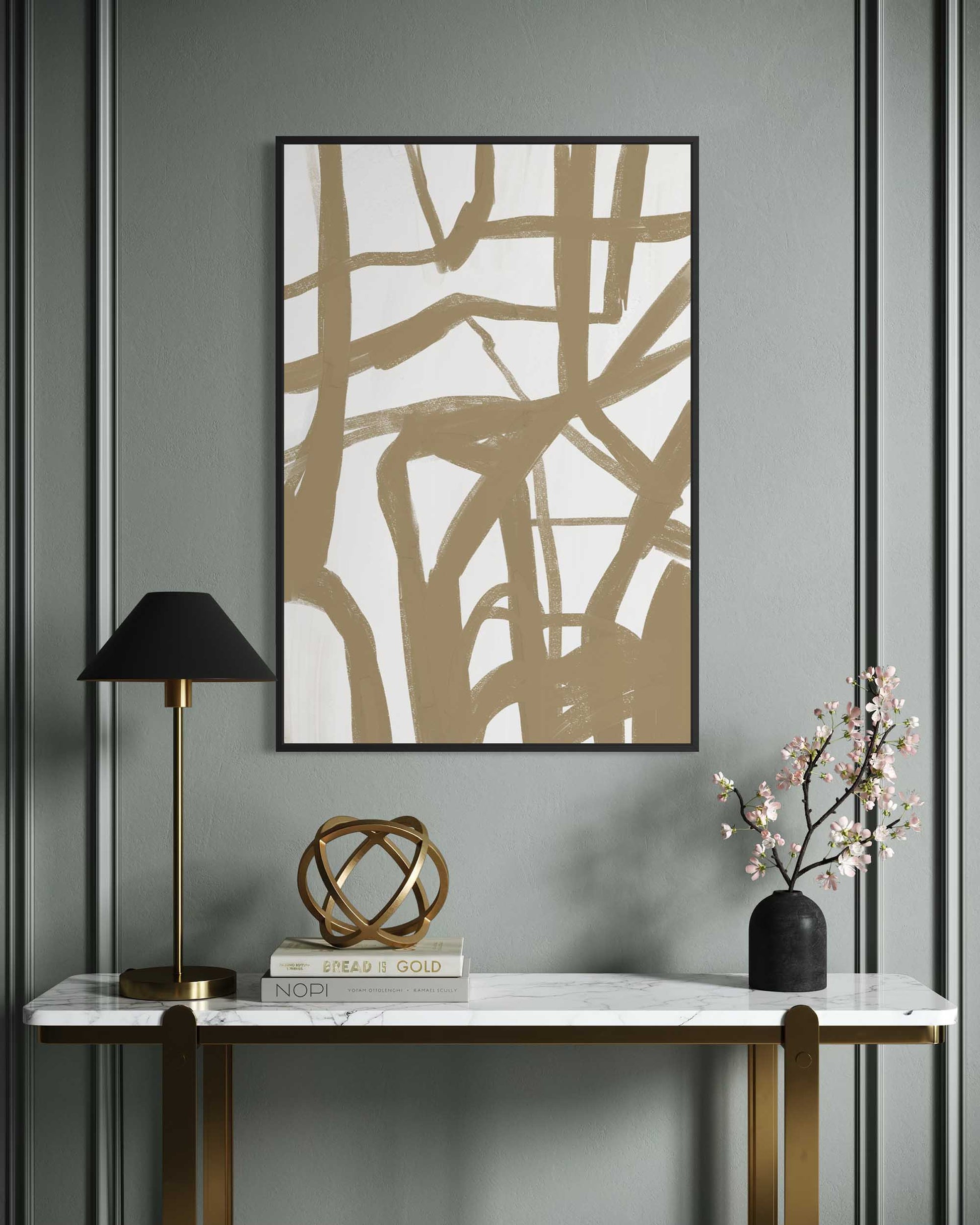 Abstract art piece on a wall above a console table with decor items.