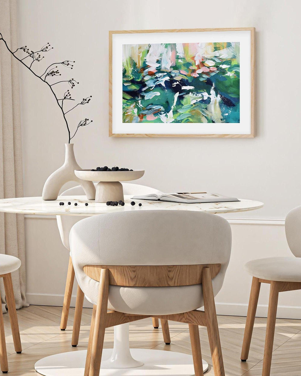 Modern dining room with round table and chairs, abstract painting on the wall.