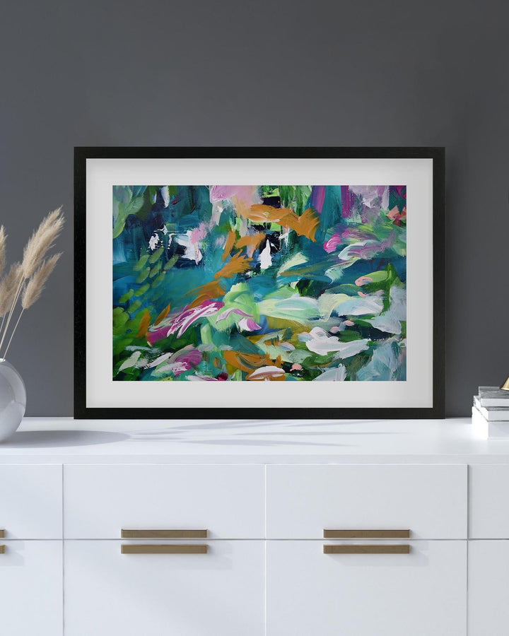 Framed abstract painting on a white surface with a dark gray wall background