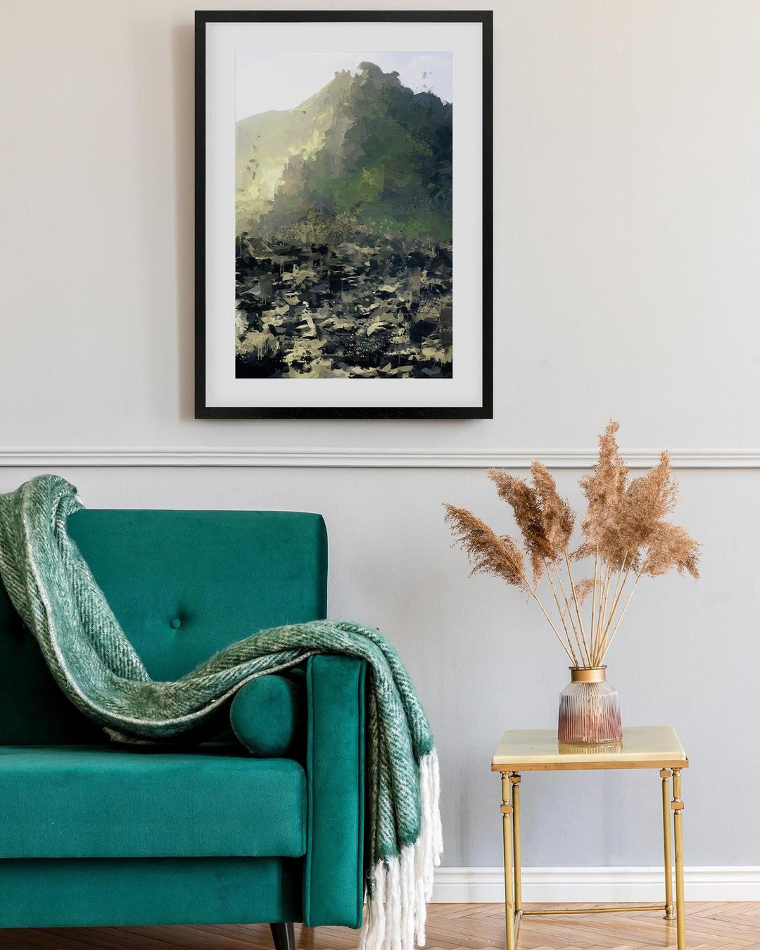 Teal armchair with a green blanket, framed artwork on the wall, and a small table with dried plants.