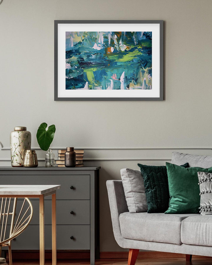 Living room with a framed abstract painting on the wall, a sofa with pillows, and a side table.