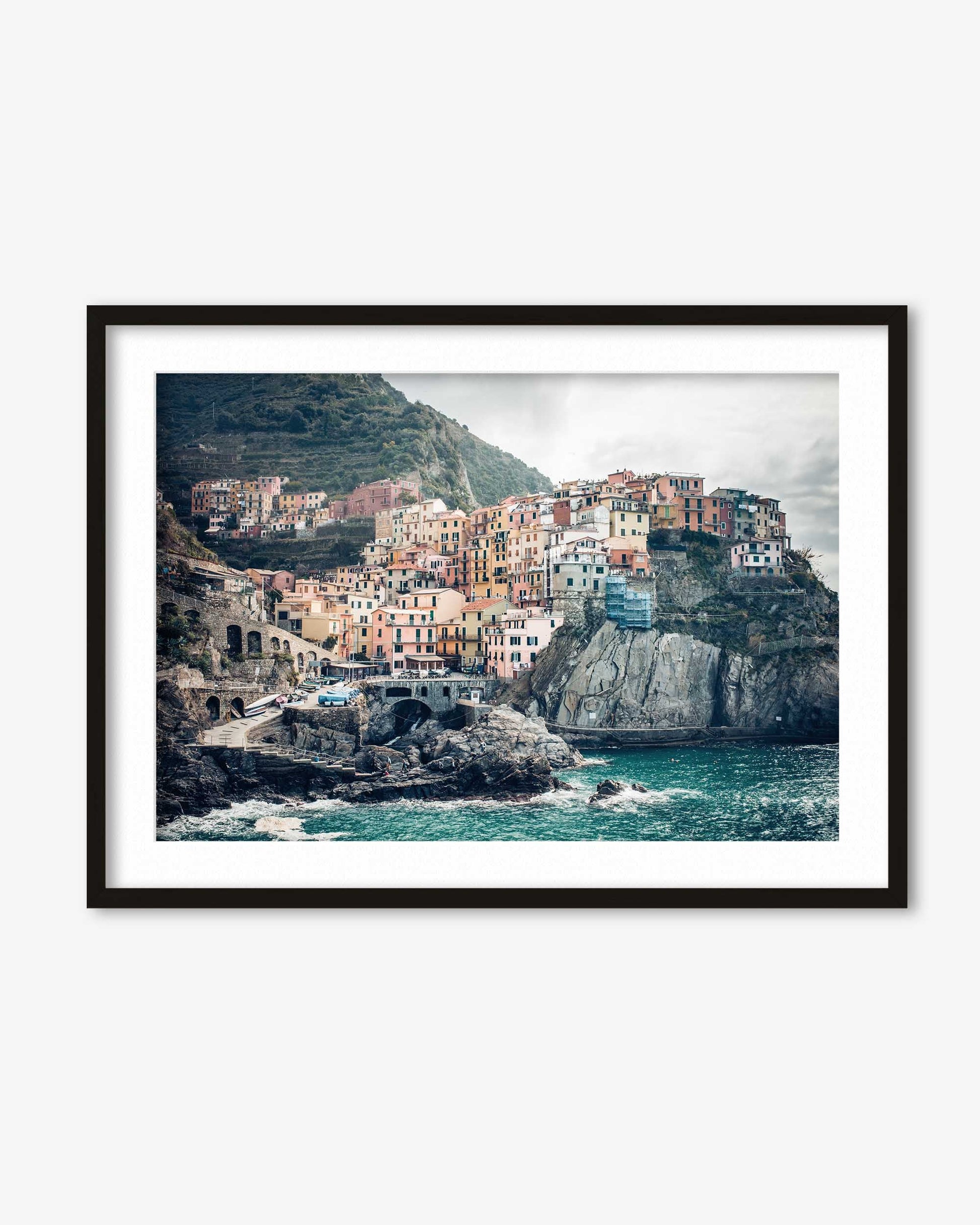 Framed photograph of a coastal village with colorful buildings and ocean view.