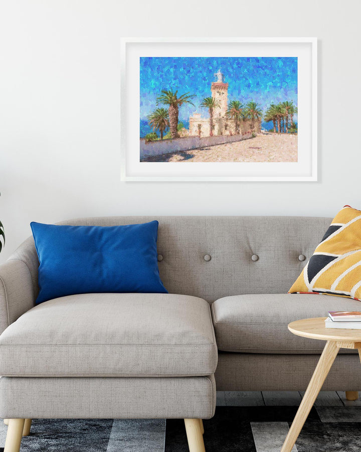 Framed artwork of a coastal scene with a lighthouse above a sofa with colorful cushions.