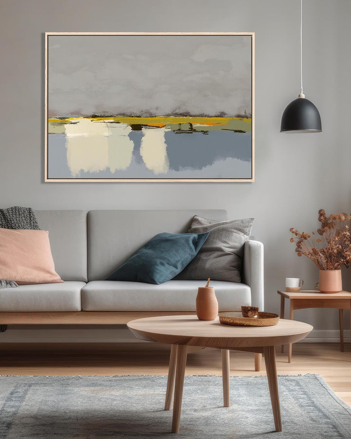 Modern living room with a gray sofa, wooden coffee table, and abstract painting on the wall.