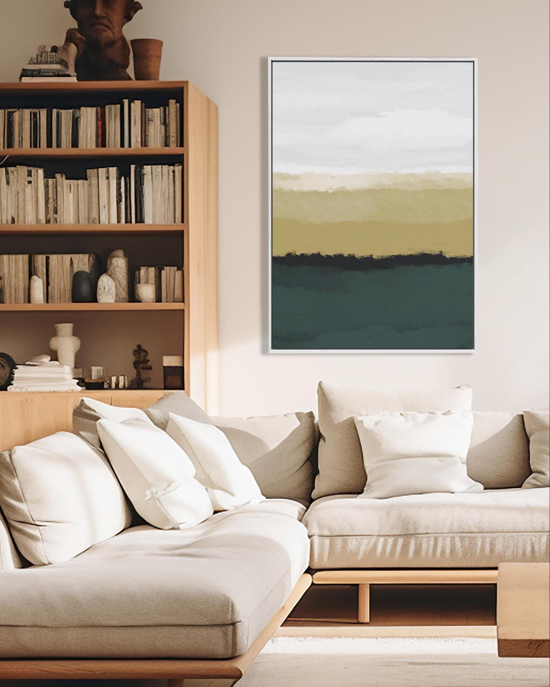 Modern living room with a beige sofa, bookshelf, and abstract painting.
