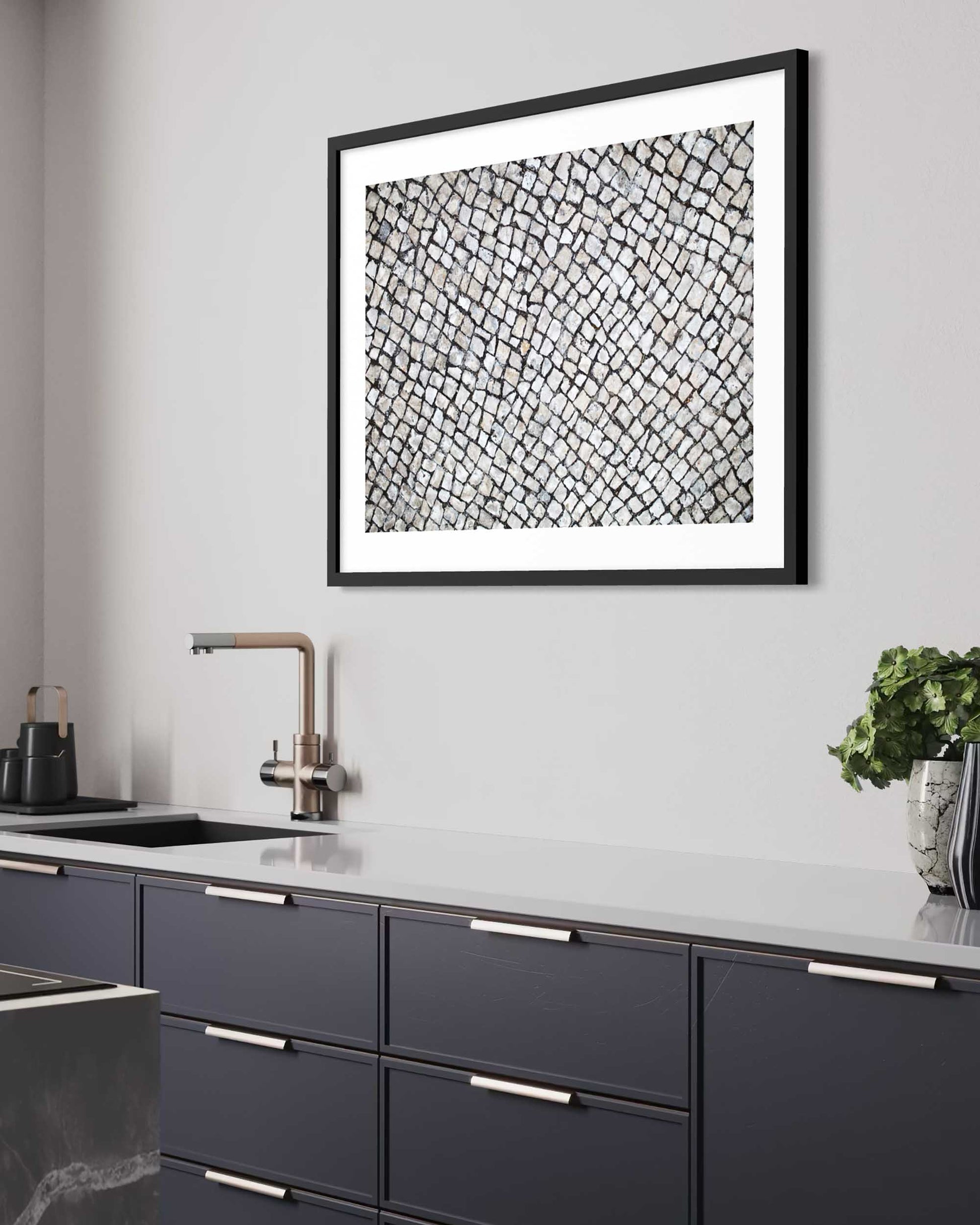 Modern kitchen with dark blue cabinets, white countertop, and abstract black and white artwork on the wall.