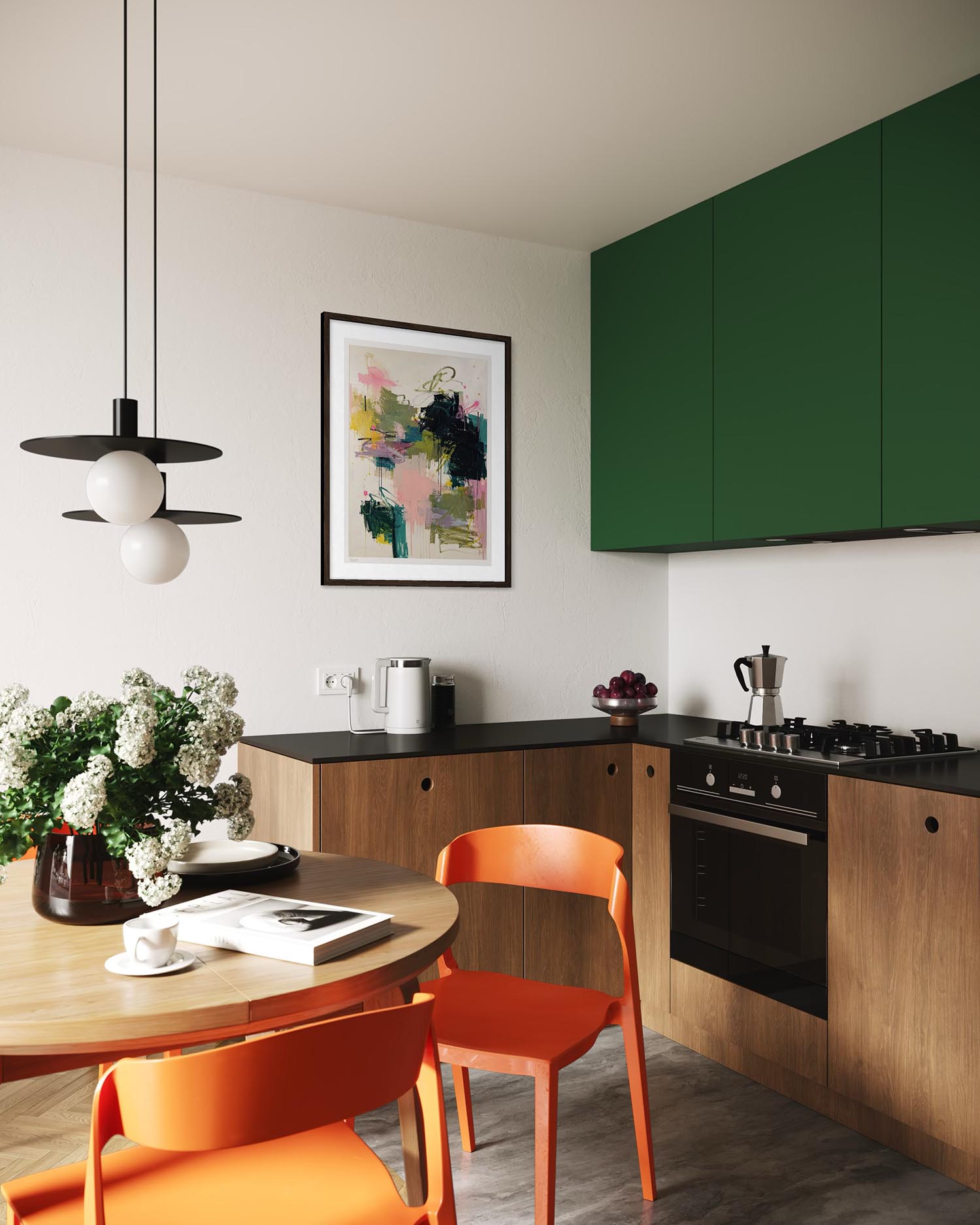A modern kitchen interior with dark green upper cabinets, light wood lower cabinets, black countertops, a built-in oven, and orange chairs around a round wooden dining table. A black pendant light hangs above, and framed abstract wall art is visible on the white wall.