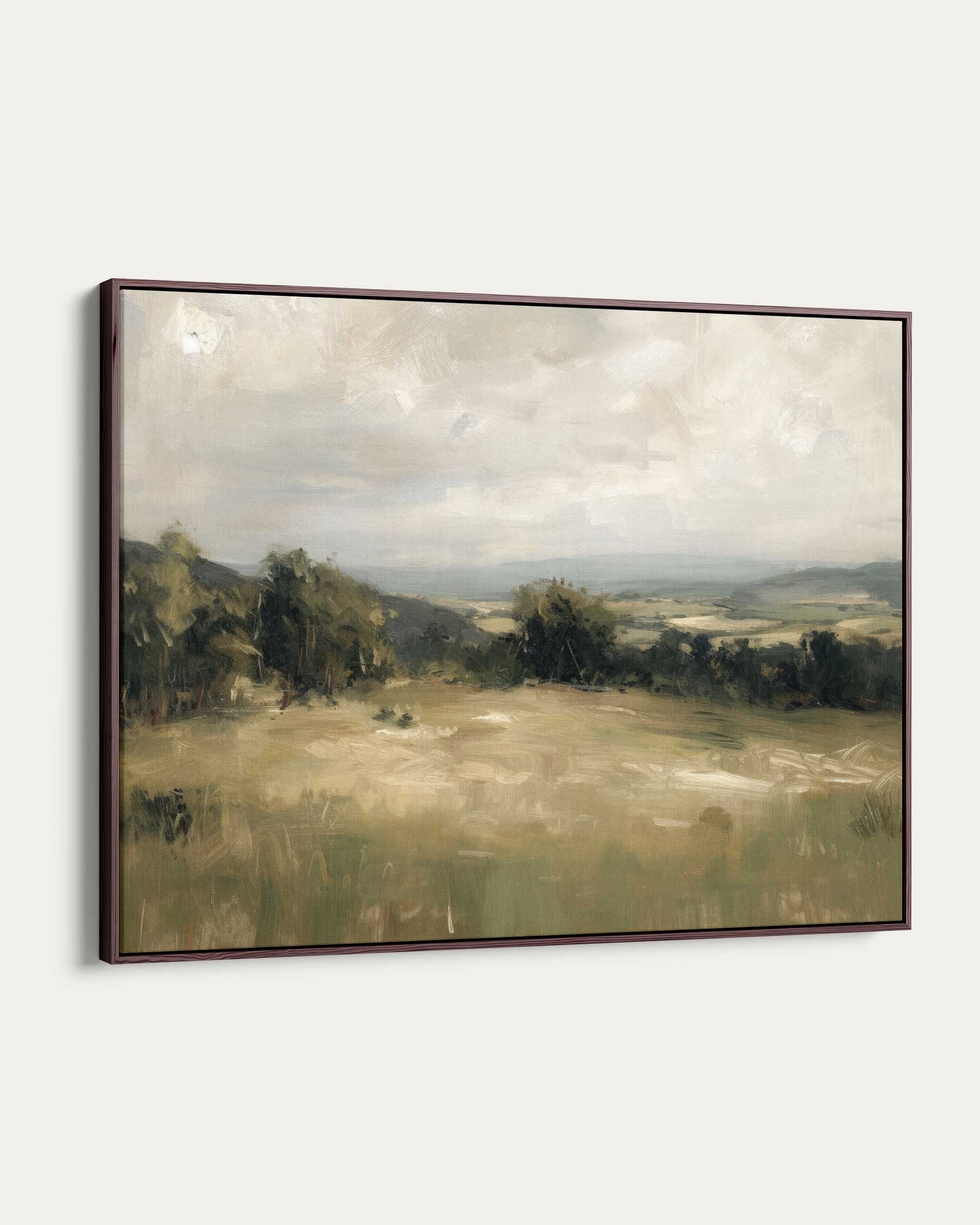 Framed painting of a landscape with fields and trees on a white wall
