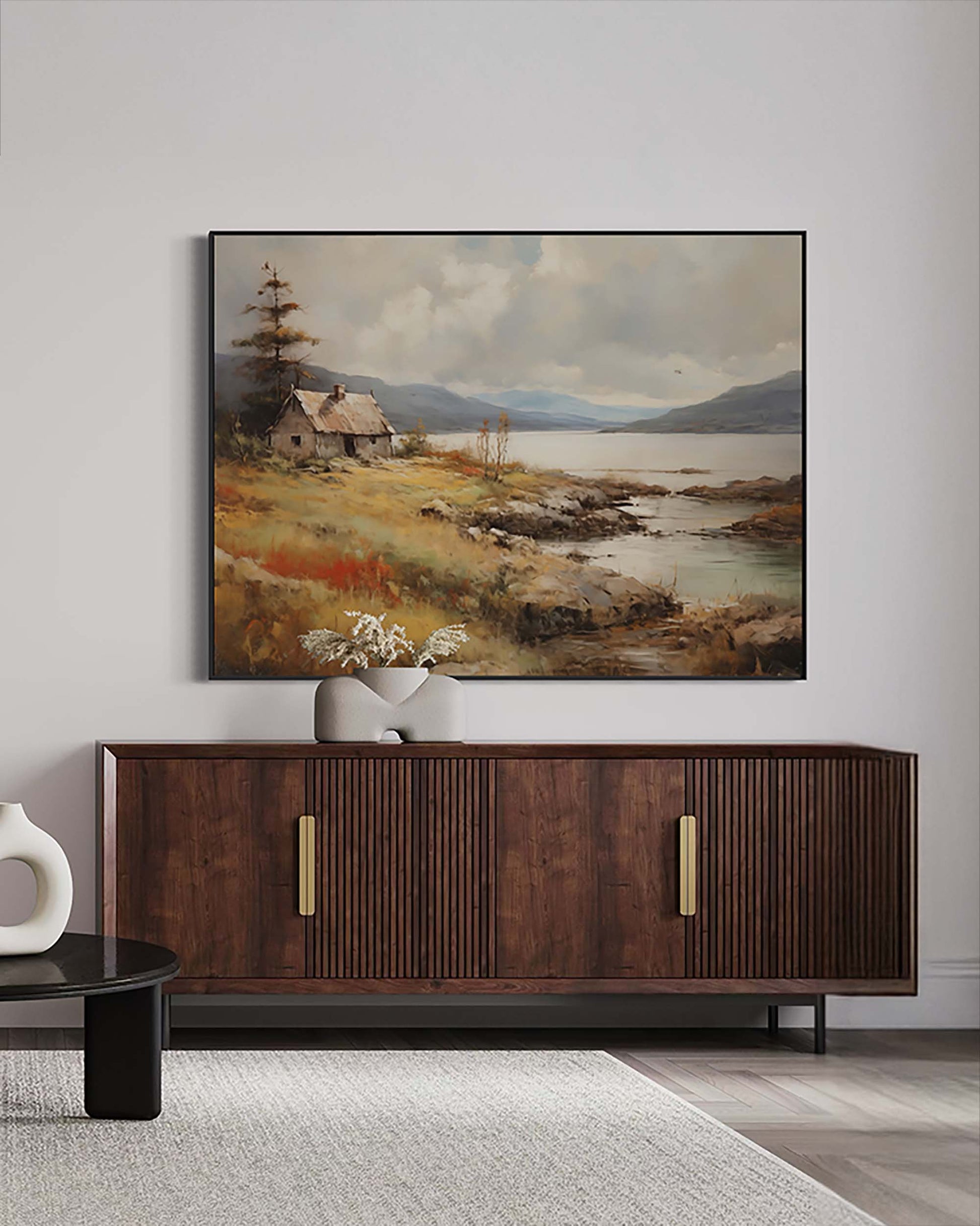 Framed landscape painting above a wooden cabinet in a room.