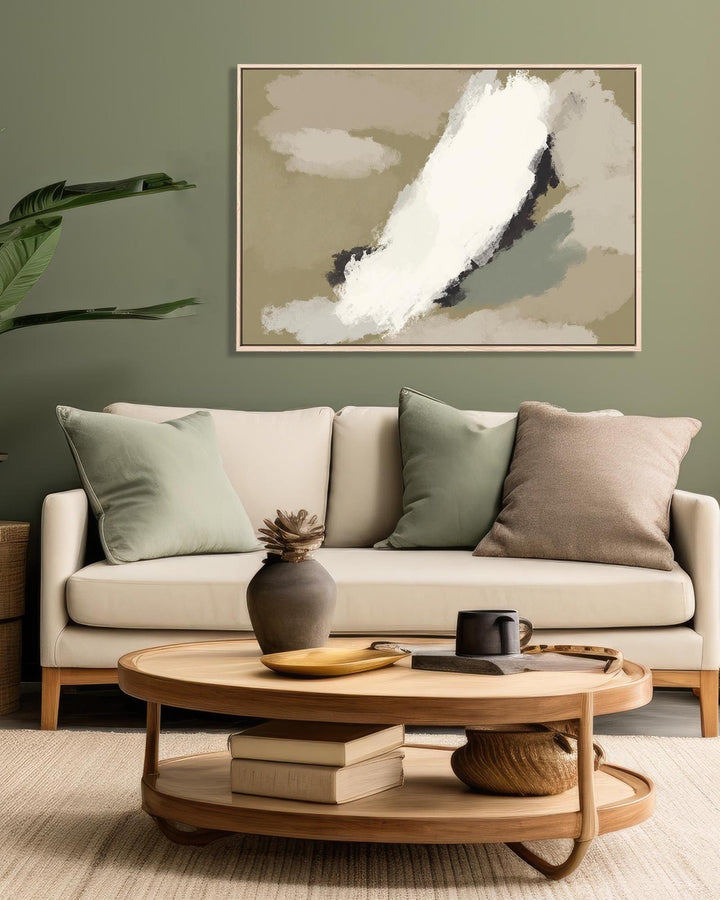 Living room with a beige sofa, round wooden coffee table, and abstract art on the wall.