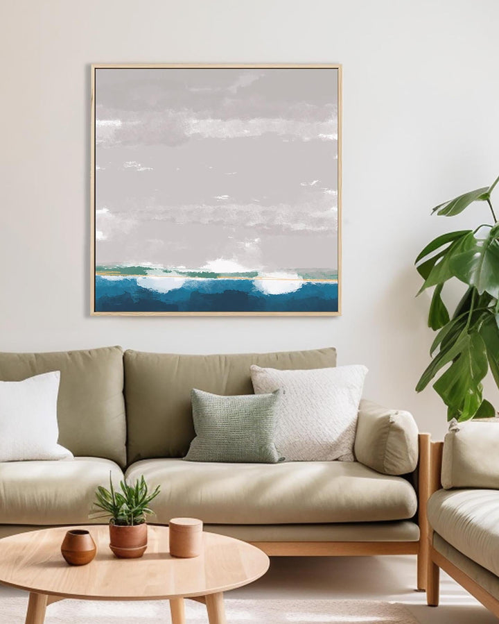 Modern living room with a beige sofa, wooden coffee table, and a framed landscape painting on the wall.