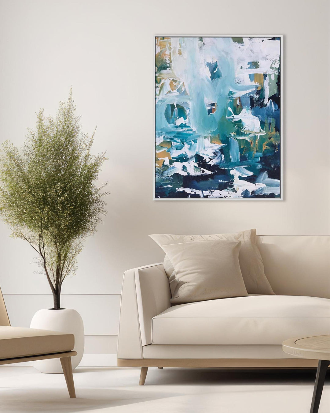 Abstract painting in a modern living room with a beige sofa and plant.