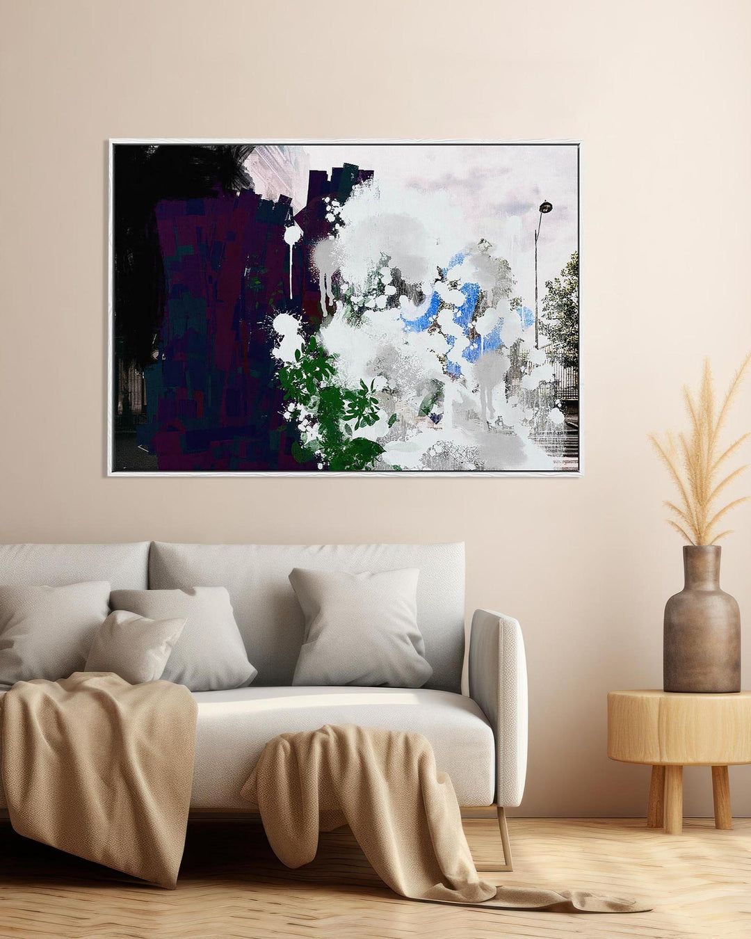 Modern living room with a white sofa, abstract painting on the wall, and a small wooden table with a vase.