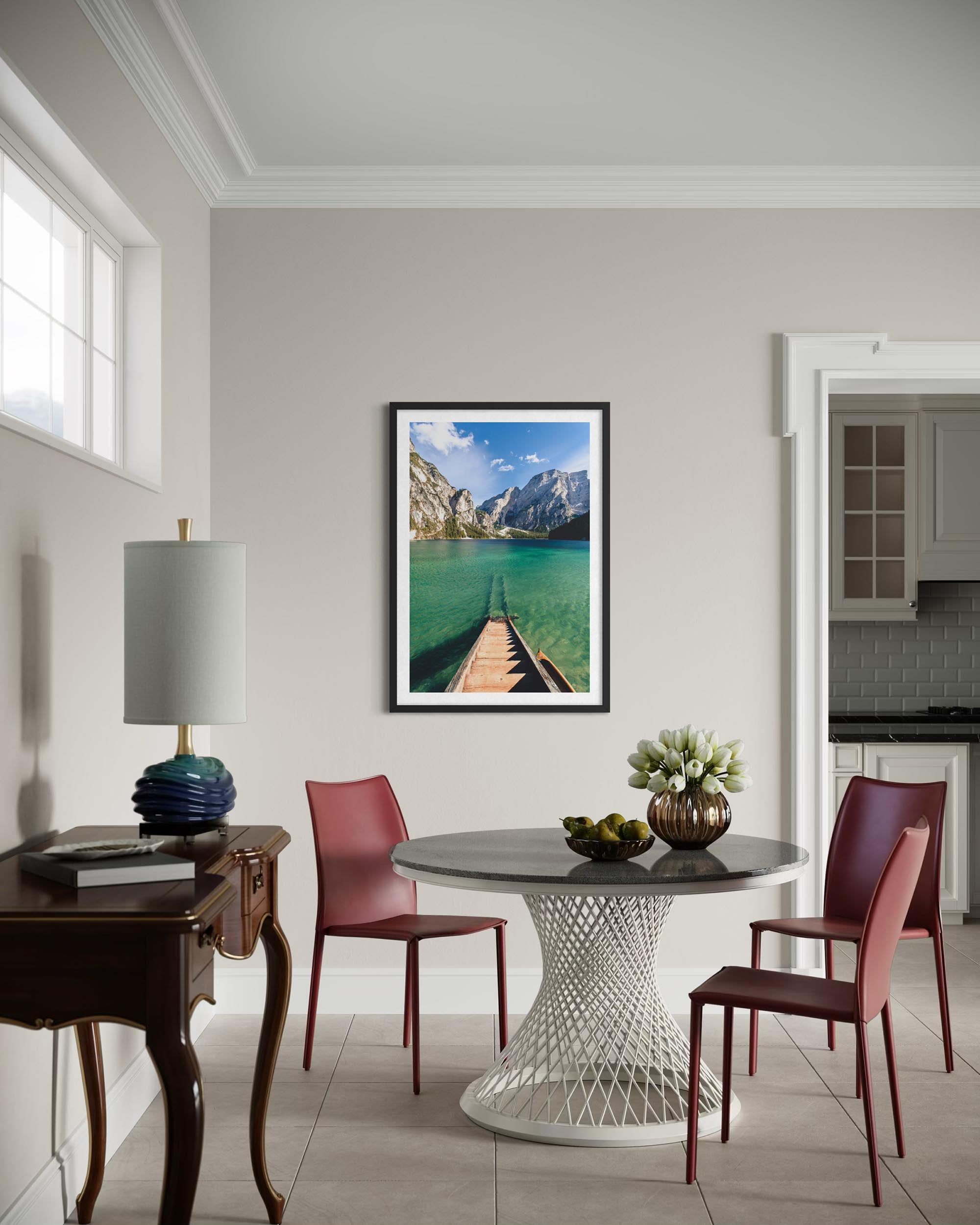 Dining room with a table, chairs, and a framed picture of a mountain lake on the wall.