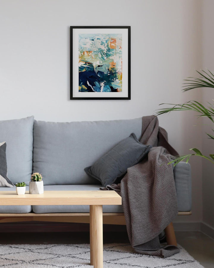 Living room with a gray sofa, wooden coffee table, and abstract art on the wall.